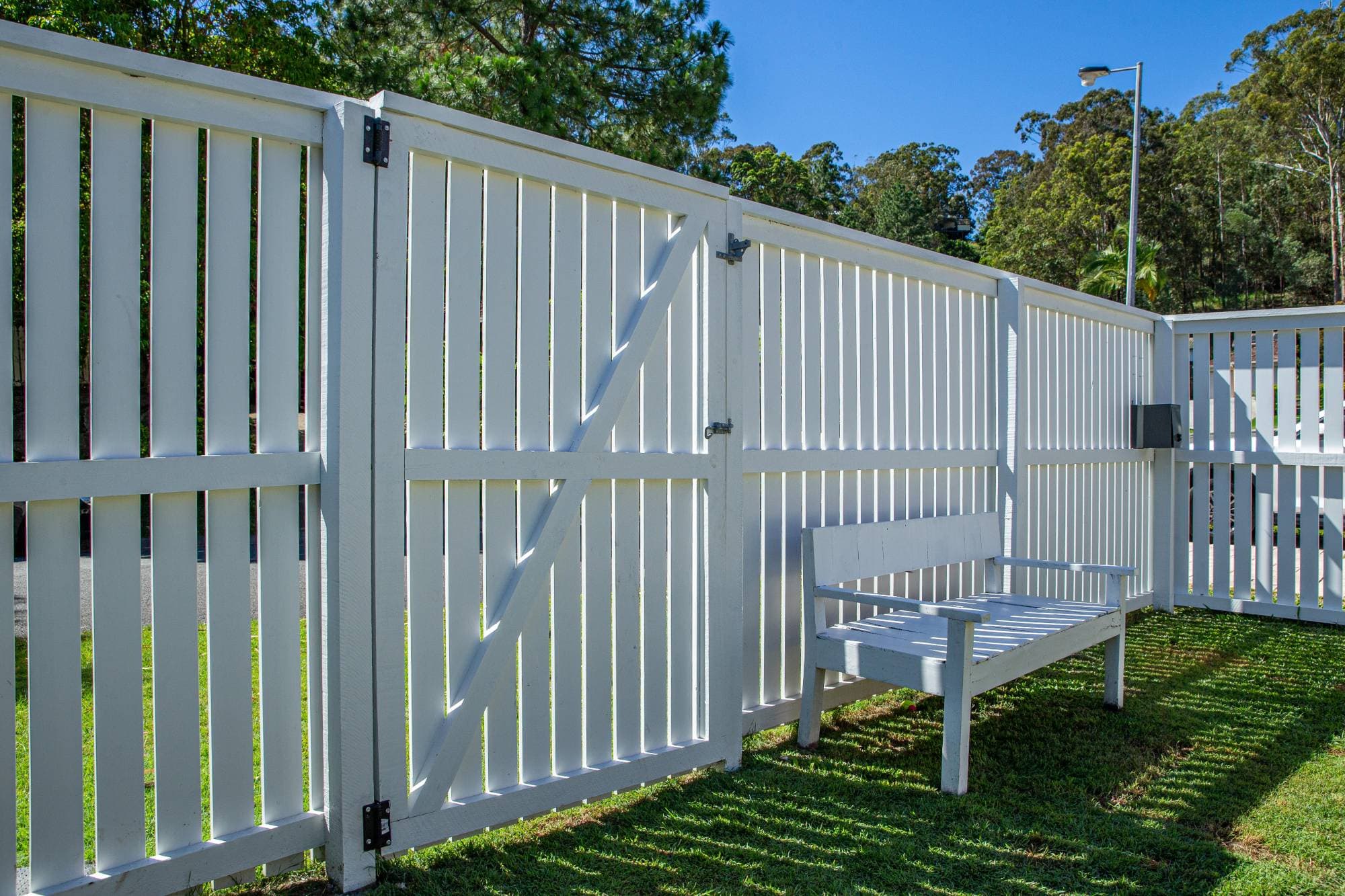 White timber gate set into a picket fence